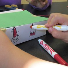 a child is drawing with crayons on paper