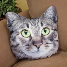 a cat's face is shown on a pillow that looks like it has green eyes