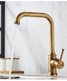 a faucet with water running out of it in a kitchen sink next to a white counter top