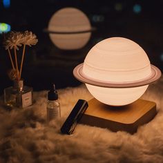 a small white ball sitting on top of a wooden stand next to bottles and flowers