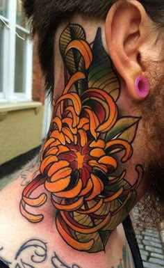 a man with a tattoo on his neck and behind the ear is an orange flower