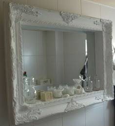 a bathroom mirror sitting above a sink under a faucet