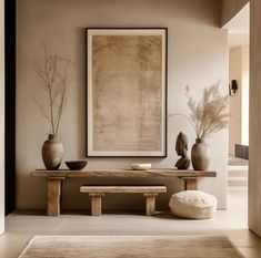 a table with two vases on top of it next to a bench and ottoman