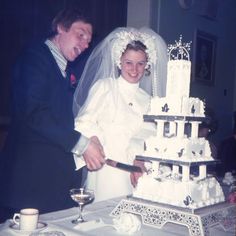 the bride and groom are cutting their wedding cake at the table with glasses on it