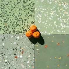 three oranges are sitting on the ground next to each other in different colors and shapes