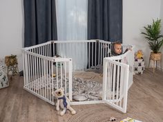 a baby in a crib next to two teddy bears