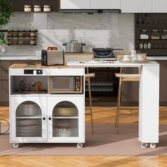 a kitchen with a white island and wooden floors