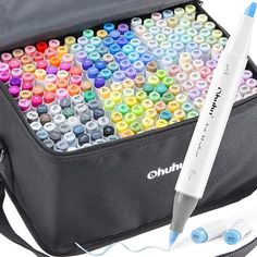 a bag filled with lots of colorful crayons next to a white marker pen