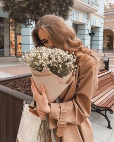 a woman holding a bunch of flowers in her hand