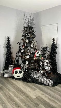 a christmas tree decorated with black and white ornaments is shown in the corner of a room