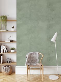 an empty room with a chair, lamp and bookshelf