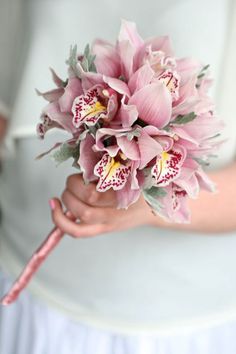 a bride holding a bouquet of pink flowers