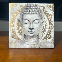 a white buddha statue sitting on top of a wooden table