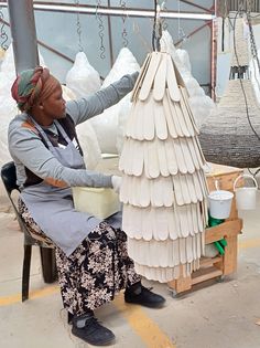 a woman sitting in front of a white sculpture