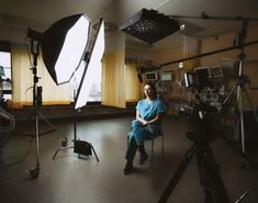 a woman sitting on a chair in front of a camera