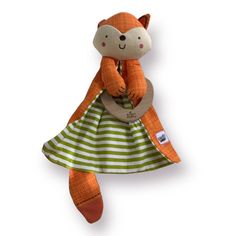 an orange and green stuffed animal wearing a dress with stripes on it's chest