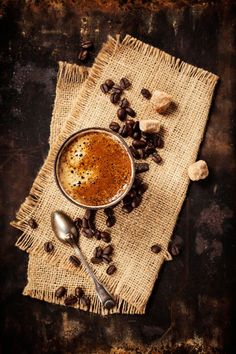 a cup of coffee and some beans on a table