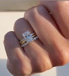 a woman's hand with two rings on it and one is holding the other