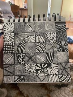 a spiral notebook with black and white designs on it