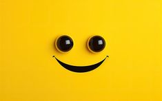 a smiley face with two black eyes on a yellow background that looks like it's smiling