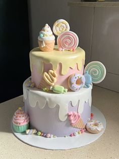 a multi layer cake decorated with candy and lollipops