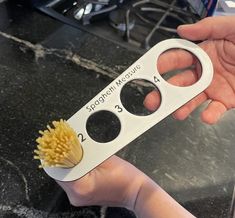 a person holding a toothbrush in their hand with the handle open and two holes missing