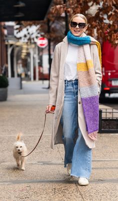 a woman walking her dog down the street