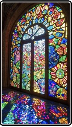 a large stained glass window in the middle of a room with sunlight coming through it