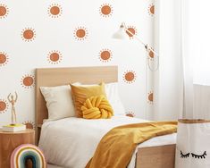 a bedroom with sun decals on the wall, and a bed in front of it