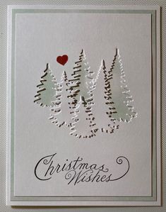 a christmas card with pine trees and a red heart on it's back,