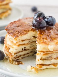 pancakes with blueberries and syrup on white plates