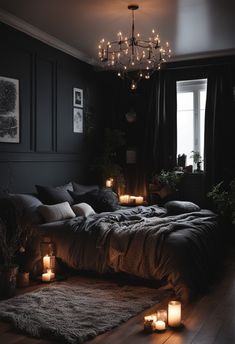 a dark bedroom with candles lit on the floor