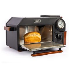 an old fashioned toaster oven with a loaf of bread in it