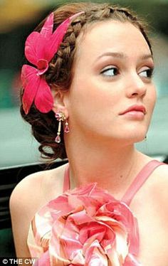 a woman in a pink dress with flowers on her head sitting next to a car