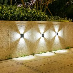 four lights on the side of a wall at night