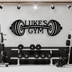 there is a gym with dumbs and barbells on the wall in front of it