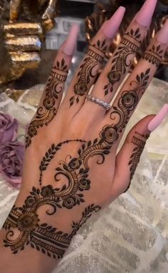 a woman's hand is decorated with hennap and rings on it,