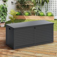 an outdoor storage box sitting on top of a wooden deck next to potted plants