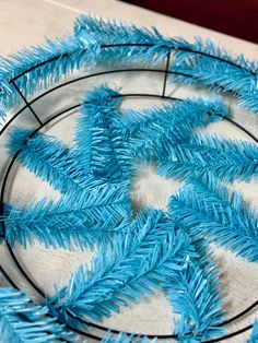 a blue tinsel christmas tree ornament sitting on top of a table