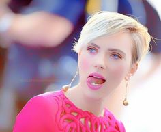 a woman with short blonde hair and blue eyes is making a funny face at the camera