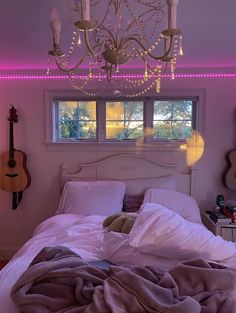 a bedroom with a bed, chandelier and guitar