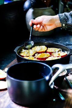 a person cooking food in a skillet on a table