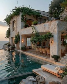 a house with a swimming pool next to it and lots of greenery on the roof