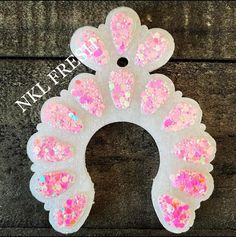 a paper plate with pink and white glitters on it, in the shape of a wreath