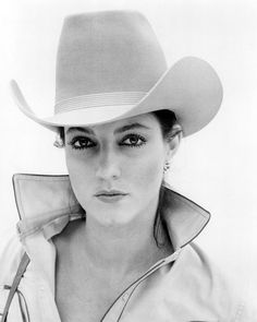 a black and white photo of a woman wearing a cowboy hat with the caption explore