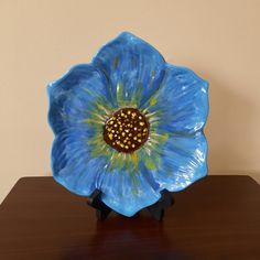 a blue flower shaped plate sitting on top of a wooden table