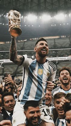 a man is holding up a trophy while surrounded by fans