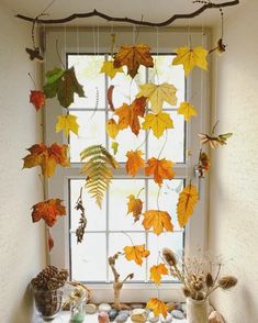 a window sill filled with lots of autumn leaves and branches hanging from it's side