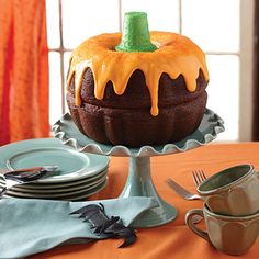 a cake sitting on top of a table covered in frosting and orange icing