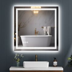 a white bath tub sitting under a bathroom mirror next to a counter top with a sink